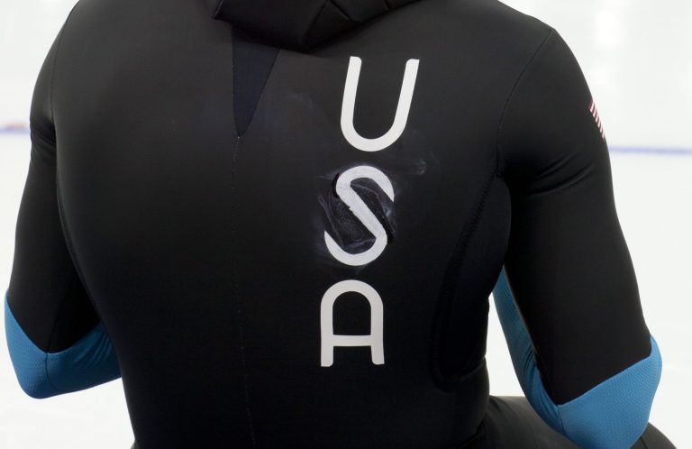 U.S. speedskater Joey Mantia rests, wearing the old World Cup race suit with makeshift letters of the country marked over a patched area, prior to the men's 1,500-meter race at the Adler Arena Skating Center during the 2014 Winter Olympics in Sochi, Russia, Saturday, Feb. 15, 2014. U.S. skaters are looking to bounce back from an awful start to their Olympics by slipping back into their old suits that should have been made obsolete by new high-tech gear. (AP Photo/Peter Dejong)