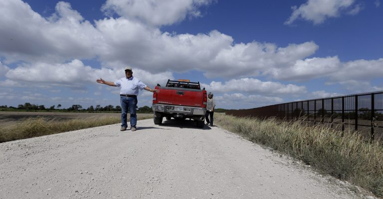 Cotton farmer Teofilo âJuniorâ Flores, left, with his wife, Maria Flores, talks about the U.S.-Mexico border fence that passes through his property in Brownsville, Texas. (AP Photo/Eric Gay)
