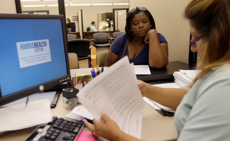 Lillian Ardon, right, a certified application counselor with Harris Health System, helps Vanessa Danielle Cotton, left, with her Affordable Care Act marketplace application on Oct. 1 in Houston. (AP Photo/David J. Phillip)