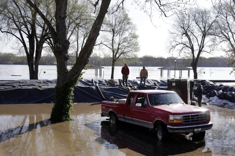 Men work along a temporary levee in an effort to hold back the swollen Mississippi River Saturday, April 20, 2013, in Clarksville, Mo. Communities along the Mississippi River and other rain-engorged waterways are waging feverish bids to hold back floodwaters that may soon approach record levels. (AP Photo/Jeff Roberson)
