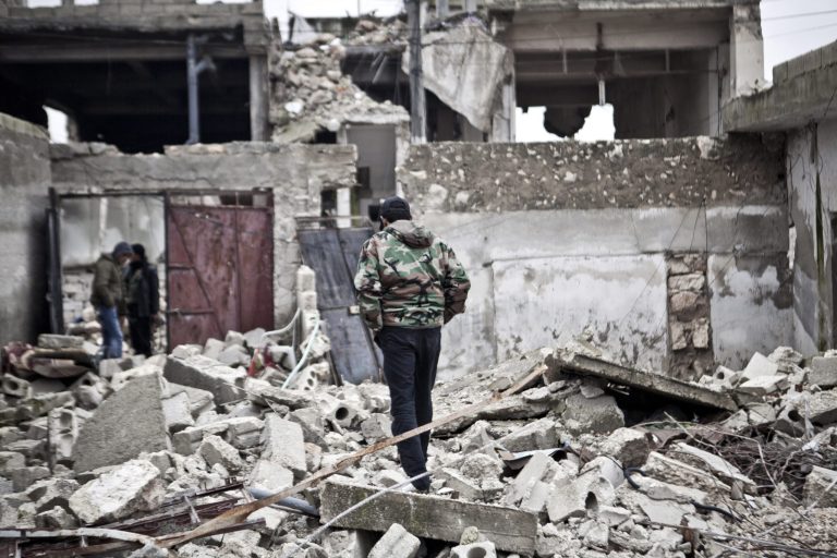   Free Syrian Army fighters walk amid the ruins of a village situated a short distance from an area where fighting between rebels and government forces continues, Saturday, Dec. 22, 2012. (AP Photo/Virginie Nguyen Hoang)  