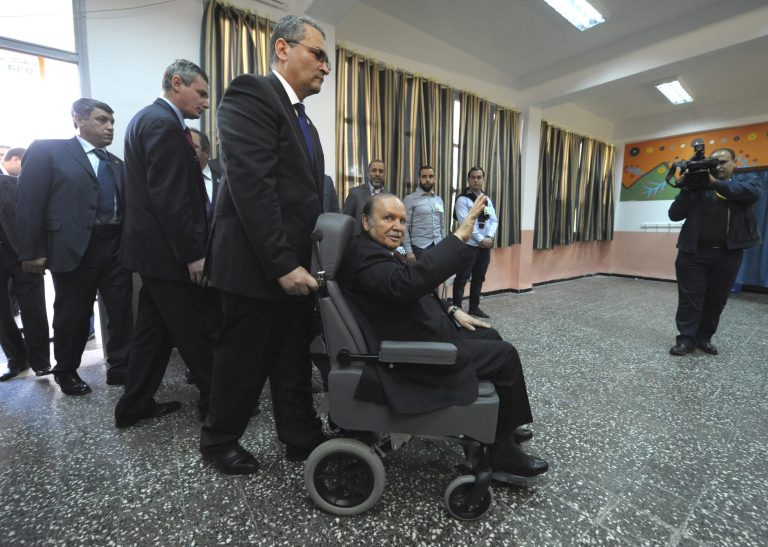 President Abdelaziz Bouteflika arrives on a wheelchair to vote in the presidential elections in Algiers, Thursday, April 17, 2014. Algerians are trickling into the polls to elect a new president of this oil-rich North African nation in an election expected to be won by the ailing incumbent. President Bouteflika has ruled this nation for the past 15 years and, despite suffering from a stroke, is running for a fourth term on a platform of stability. (AP Photo/Sidali Djarboub)