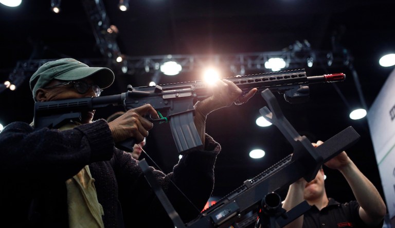 An attendee fires an AR-15 style airgun during a laser simulation at the National Rifle Association's annual meeting in 2016. Some U.S. companies have begun pulling away from the powerful gun-lobbying group in the wake of a mass shooting at a Florida high school. (Luke Sharrett/Bloomberg)