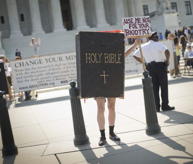 A demonstrator dressed as the 'Bible' stands outside the Supreme Court building awaiting the court's decision on the Hobby Lobby case in Washington on Monday. (AP/Pablo Martinez Monsivais)