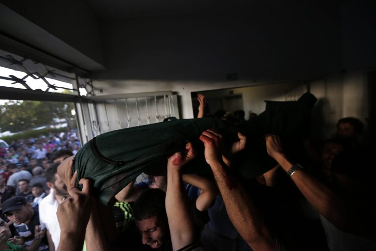Palestinian mourners carry the body of their loved one, killed on an Israeli strike in Shijaiyah neighbourhood, out of the morgue of Gaza City's Shifa hospital, during the funeral, on Wednesday, July 30, 2014. Israeli strikes hit the crowded shopping area in Gaza City, hours after tank shells tore through the walls of a U.N. school crowded with war refugees Wednesday in the deadliest of a series of air and artillery attacks that push the Palestinian death toll above 1,300 in more than three weeks of fighting.(AP Photo/Lefteris Pitarakis)