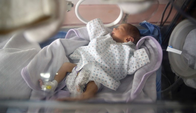 A baby lies in a crib at the Ataturk Children's Hospital a day after being rescued from another maternity hospital following a deadly attack, in Kabul, Afghanistan, Wednesday, May 13, 2020. Militants stormed the Barchi National Maternity Hospital in the western part of Kabul on Tuesday, setting off an hours-long shootout with the police and killing tens of people, including two newborn babies, their mothers and an unspecified number of nurses, Afghan officials said.