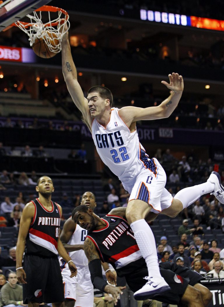   Charlotte Bobcats' Byron Mullens (22) dunks over Portland Trail Blazers' LaMarcus Aldridge (12) during the first half of an NBA basketball game in Charlotte, N.C., Monday, Dec. 3, 2012. (AP Photo/Chuck Burton)  