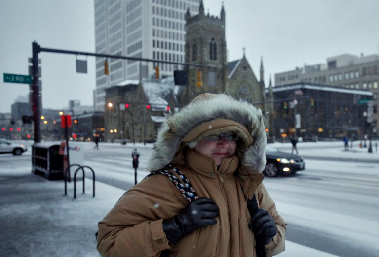   Karen Boyd walks West on East Broad St on her way to a downtown Columbus, Ohio office building on Wednesday, Dec. 26, 2012 as Ohio gets hammered by a winter snow storm. (AP Photo/Columbus Dispatch, Tom Dodge)  