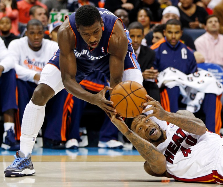   Miami Heat's Udonis Haslem, bottom, looks to pass as Charlotte Bobcats' Michael Kidd-Gilchrist, top, defends during the first half of an NBA basketball game in Charlotte, N.C., Wednesday, Dec. 26, 2012. (AP Photo/Chuck Burton)  