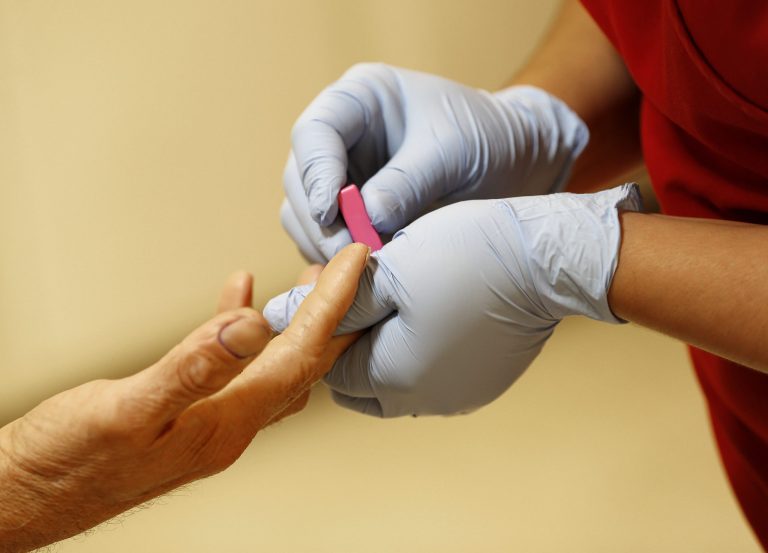 Lab technician draws blood at a health care center for uninsured patients in downtown Phoenix. The Treasury Department announced Tuesday that it would be delaying implementation of Obamacareâs employer mandate. (Matt York/AP)