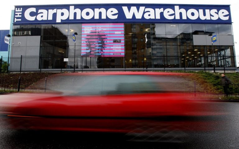 FILE - This is a  Monday, Dec. 8, 2008 file photo of  a car as it passes the offices of Carphone Warehouse in London.  British cellphone seller Carphone Warehouse and consumer electronics retailer Dixons Retail Group have announced plans to merge in a deal that values the combined business at 3.8 billion pounds ($6.4 billion). (AP Photo/Kirsty Wigglesworth, File)