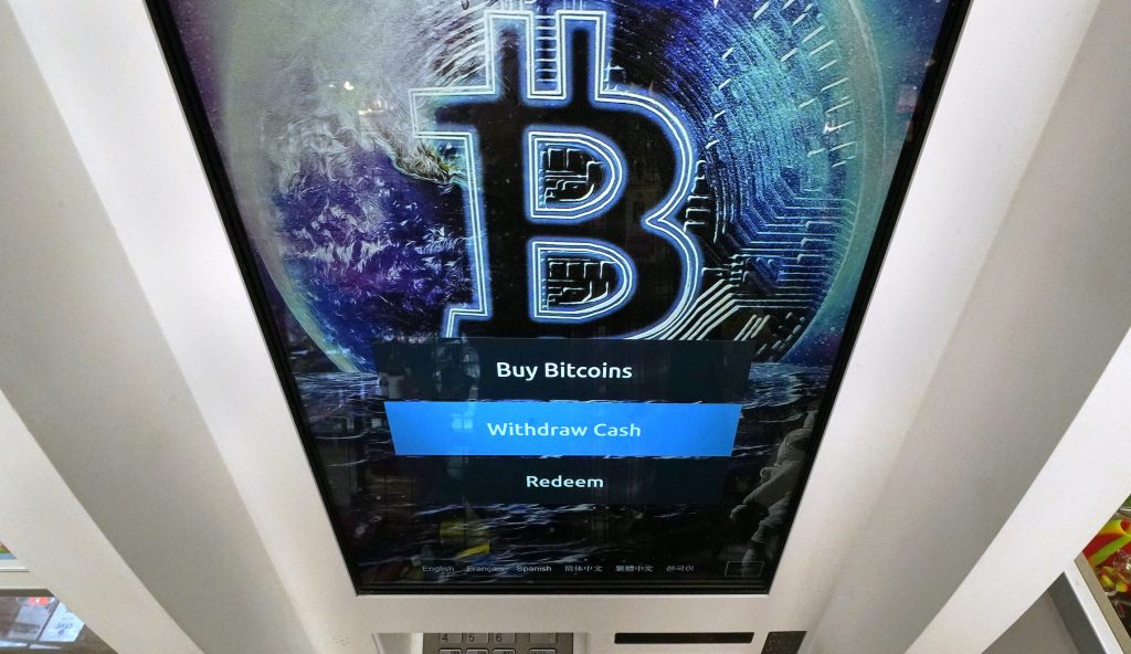 The Bitcoin logo appears on the display screen of a crypto currency ATM at the Smokerâs Choice store, Tuesday, Feb. 9, 2021, in Salem, N.H. The price of Bitcoin has soared over the past months. (AP Photo/Charles Krupa)
