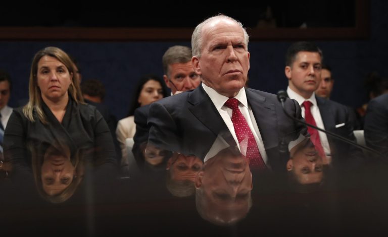Former CIA Director John Brennan is reflected in a table as he prepares to testify on CapitolHill in Washington, Tuesday, May 23, 2017, before the House Intelligence Committee Russia Investigation Task Force.
