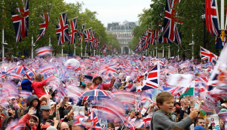 FILE - In this June 5, 2012 file photo revelers on the Mall in London watch Britain Queen Elizabeth II appear on the Buckingham Palace balcony as part of a four-day Diamond Jubilee celebration to mark the 60th anniversary of  Queen Elizabeth II accession to the throne.