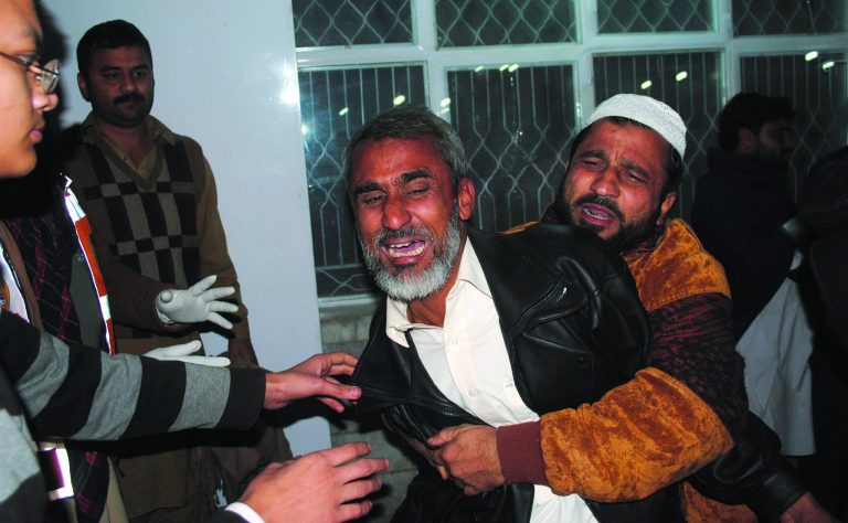 Pakistanis mourn for their relative killed in a suicide bombing, at a local hospital in Peshawar, Pakistan, Saturday, Dec. 22, 2012. A suicide bomber in Pakistan killed several people including a provincial government official at a political rally held Saturday by a party that has opposed the Taliban, officials said. (AP Photo/Mohammad Sajjad)