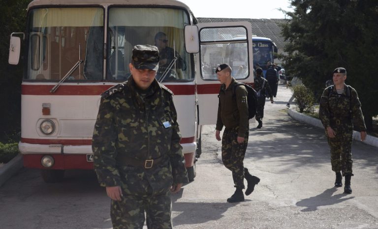 Ukrainian marines prepare to leave their base in Feodosia, Crimea, Tuesday, March 25, 2014. In Crimea, Ukrainian soldiers piled onto buses and began their journey to Ukrainian territory on Tuesday, as former comrades saluted them from outside a base overrun by Russian forces. (AP Photo/Valeriy Kulyk)