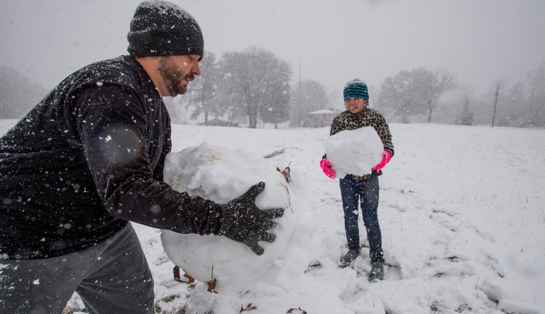 Stephen Fanning and his daughter Addison Fanning build a snowman during the heavy snow fall in Clanton, Ala. on Friday, Dec. 8, 2017. (Mickey Welsh/The Montgomery Advertiser via AP)