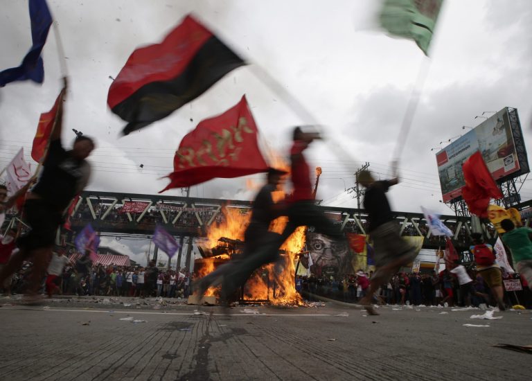 Protesters dance around the burning effigy of Philippine President Benigno Aquino III during a rally near the House of Representatives to coincide with his State of the Nation Address Monday, July 28, 2014 at suburban Quezon city, northeast of Manila, Philippines. Aquino is expected to tackle in his address, the controversial Disbursement Acceleration Program, the allocation of funds or savings by the Government to finance various programs or projects which is under the discretion of the President and was declared in part as unconstitutional by the Supreme Court. (AP Photo/Bullit Marquez)