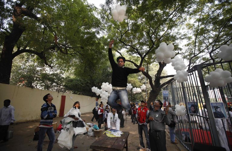 FILE - In this Saturday, Nov. 16, 2013 file photo, a Greenpeace activist jumps to catch a thread tied to balloons during a protest against the imprisonment of the group's activists and freelance journalists in New Delhi, India. India is cracking down on foreign-funded charities after receiving an internal report alleging they are costing the country up to 3 percent of its GDP by rallying communities against polluting industries. (AP Photo/Altaf Qadri, File)