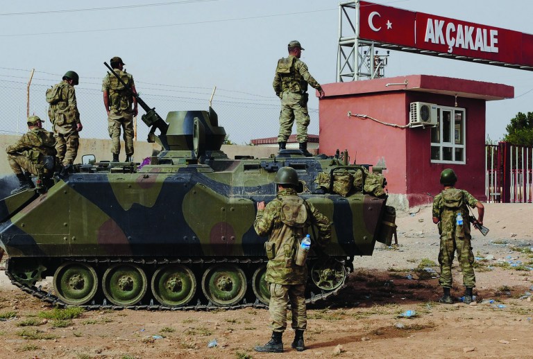 FILE - In this Sunday, Oct. 7, 2012 file photo, Turkish military station at the border gate with Syria, across from Syrian rebel-controlled Tel Abyad town, in Akcakale, Turkey. Syria and Turkey exchange fire across their troubled border for a sixth straight day, attacks that look increasingly like an intentional escalation by President Bashar Assad to send a message to his northern neighbor that it will pay dearly for supporting the rebels. (AP Photo, File)