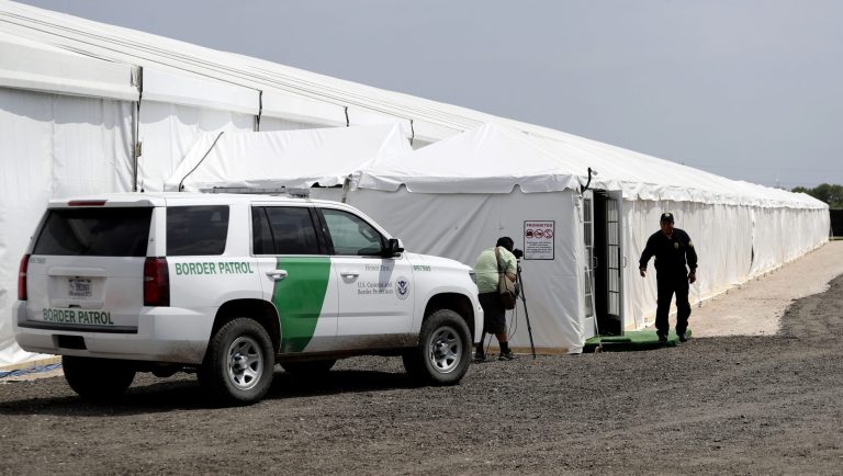 A security guard enters a new U.S. Customs and Border Protection temporary facility near the Donna International Bridge, Thursday, May 2, 2019, in Donna, Texas. Officials say the site will primarily be used as a temporary site for processing and care of unaccompanied migrant children and families and will increase the Border Patrol's capacity to process migrant families. 