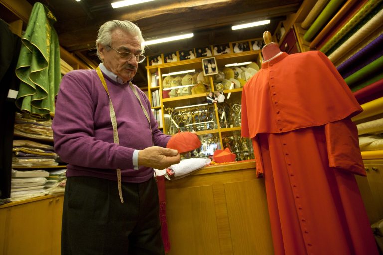 Raniero Mancinelli shows a cardinal's skull cap in his tailor shop in Rome, Thursday Feb. 13, 2014. No glitzy gold, no rich velvet, no regal fur but rather sensible black shoes and a white cassock so flimsy you can see his black trousers through it. Pope Francis has pared down the papal wardrobe to fit his call for simplicity and humility among his clergy. The pope's personal style _ which earned him Esquire magazine's 