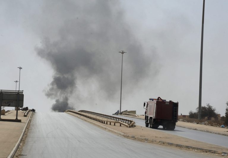 A fire truck drives towards smoke caused by an attack by Islamist militias during clashes with forces led by renegade Libyan Gen. Khalifa Hifter in Benghazi, Libya, Wednesday, Oct. 15, 2014. Islamist militias fought Wednesday with forces loyal to Hifter, who vows to seize the eastern city of Benghazi, as a top militia commander accused Egypt of bombing his positions with warplanes. (AP Photo/Mohammed el-Sheikhy)