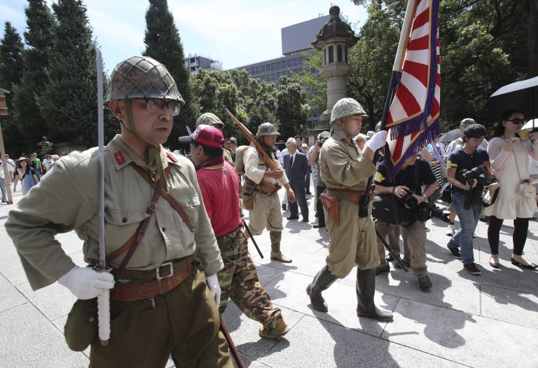 Japanese men clad in outdated military costume march in to pay respects to the country's war dead at the Yasukuni Shrine in Tokyo, Friday, Aug. 15, 2014. Japan marks the 69th anniversary of its surrender in World War II on Aug. 15. (AP Photo/Koji Sasahara)