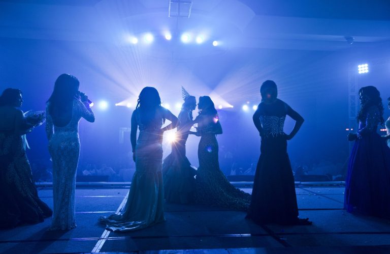In this Friday, June 20, 2014, photo, former Miss Gay Nicaragua 2013 Elizabeth Rios, center left wearing the crown, kisses a contestant competing in this year's beauty pageant in Managua, Nicaragua. Contestants paraded down the stage of a hotel auditorium in Managua last week in exuberant traditional dresses, evening gowns embellished with sequin and feathers, and in swimsuits as they competed in the beauty pageant.