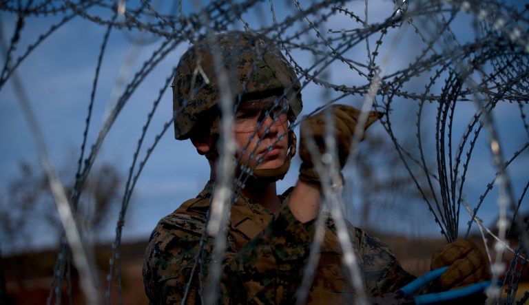 A little girl plays with a doll as Central American migrants wait in lines for a handful of buses donated to transport some of the families with small children on to the next stop in Niltepec, Oaxaca, Mexico, at dawn on Tuesday, Oct. 30, 2018.