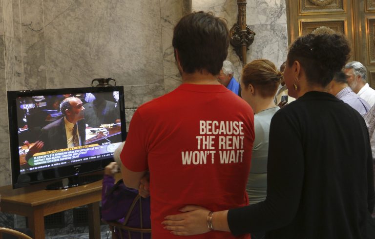 Supporters of a $15 minimum-wage initiative that passed in the city of SeaTac last year watch oral arguments on the case in the lobby of the Washington state Supreme Court on Thursday, June 26, 2014 in Olympia, Wash. The high court has been asked to decide whether the ordinance applies to airport workers. (AP Photo/Rachel La Corte)