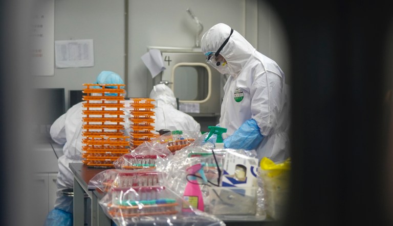 In this Saturday, Feb. 22, 2020, photo released by Xinhua News Agency, medical workers in protective suits work on nucleic acid testing work at a coronavirus detection lab in Wuhan in central China's Hubei Province. (Cheng Min/Xinhua via AP)                                              