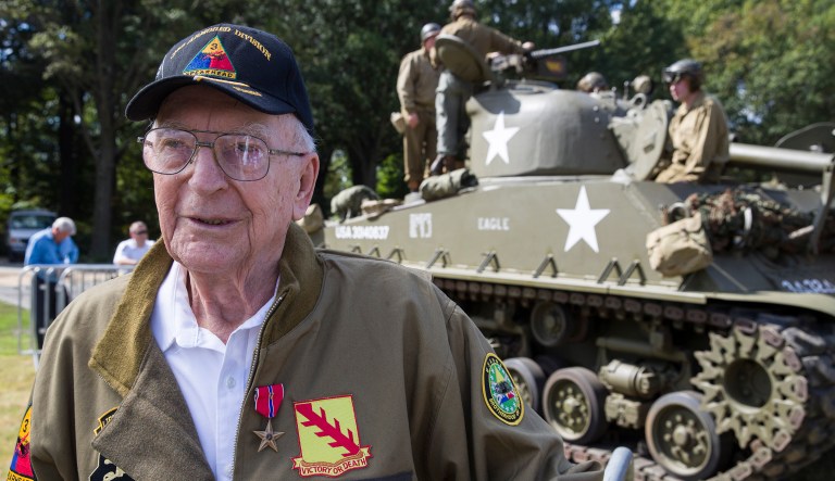 World War II veteran Clarence Smoyer, 96, poses for a picture in front of a Sherman tank after receiving the Bronze Star, near the World War II Memorial, Wednesday, Sept. 18, 2019, in Washington.