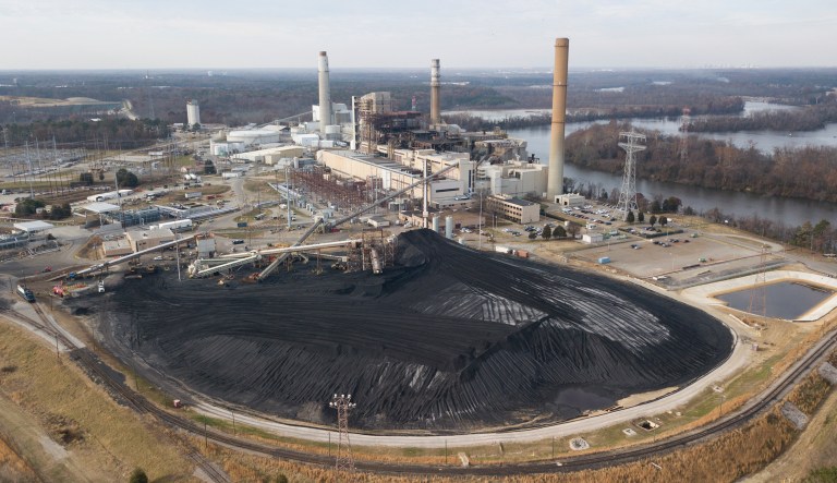 In this Dec. 4, 2017 file photo, a large field of coal is stored on the property of Dominon Energy's Chesterfield Power station along the James River in Chester, Va. One of the biggest fights at the General Assembly this year is over electric rates and whether most Virginians are paying too much on their monthly bills.