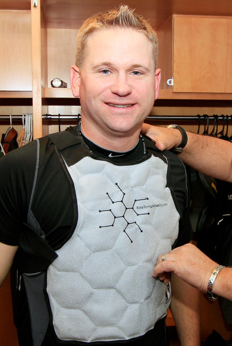   In this photo taken June 7, 2012, umpire Mike Muchlinski models a cooling vest in the umpires dressing room prior to a baseball game between the Cincinnati Reds and the Pittsburgh Pirates in Cincinnati. New technology allows umpires to wear cold packs under their shirts, an innovation that umpires say makes it feel 20 degrees cooler. (AP Photo/Al Behrman)  