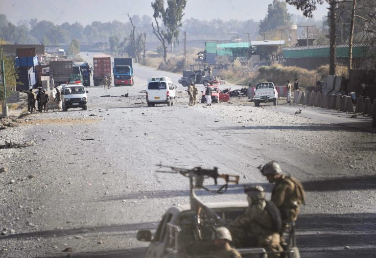   Afghan security forces block the road where Taliban suicide bombers attacked a joint U.S.- Afghan air base in Jalalabad, east of Kabul, Afghanistan on Sunday, Dec. 2, 2012. The suicide bombers attacked early Sunday, detonating explosives at the gate and sparking a gunbattle that lasted at least two hours with American helicopters firing down at militants before the attackers were defeated. (AP Photo/Nasrullah Khan)  