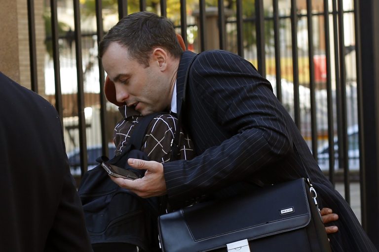 Oscar Pistorius, hugs a well-wisher as he returns to court following a lunch break in Pretoria, South Africa, Wednesday, July 2, 2014. Pistorius is severely traumatized after killing girlfriend Reeva Steenkamp last year and will become an increasing suicide risk unless he continues to get mental health care, the judge overseeing his murder trial heard on Wednesday. Defense lawyer Barry Roux read excerpts from a psychologist's report that said the double-amputee runner is suffering depression and post-traumatic stress disorder and 