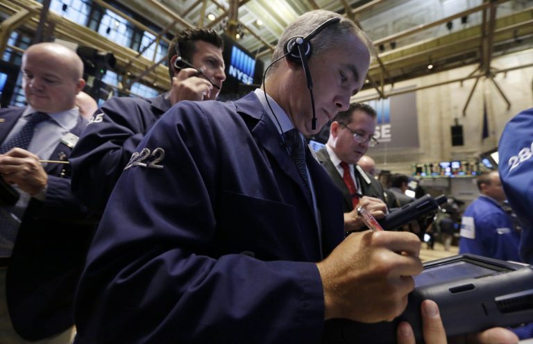 Timothy Nick, foreground center, works with fellow traders on the floor of the New York Stock Exchange Friday, Oct. 3, 2014. (AP Photo/Richard Drew)