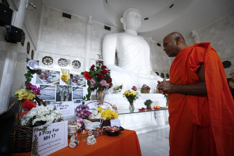 A monk prays during a special prayer for the victims of Malaysia Airlines Flight 17, Malaysia, Sunday, July 20, 2014. Malaysia's transport minister said the country is 