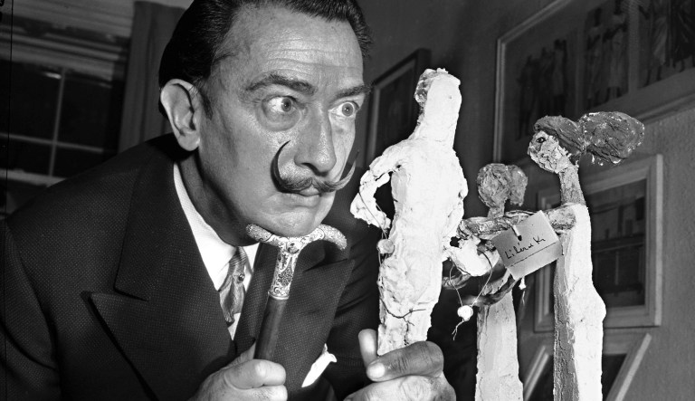 ** FILE ** Resting his chin on the handle of his cane, Spanish surrealist painter Salvador Dali studies an exhibit of contemporary Greek art in New York, Jan. 4, 1956.  Dali called his trademark mustache his "inspirational antenna."  20 years ago, on Jan. 23, 1989, Dali died. 