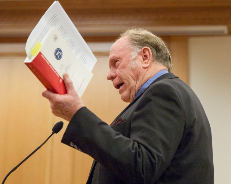 Phil Pritchard, owner of Pritchard's Distillery, holds up a copy of federal alcohol regulations during a House State Government Committee in Nashville, Tenn., Tuesday, March 18, 2014. Pritchard, whose Kelso-based distillery was exempted from last year's law establishing a legal definition of Tennessee whiskey, testified in favor a full repeal of the measure. (AP Photo/Erik Schelzig)