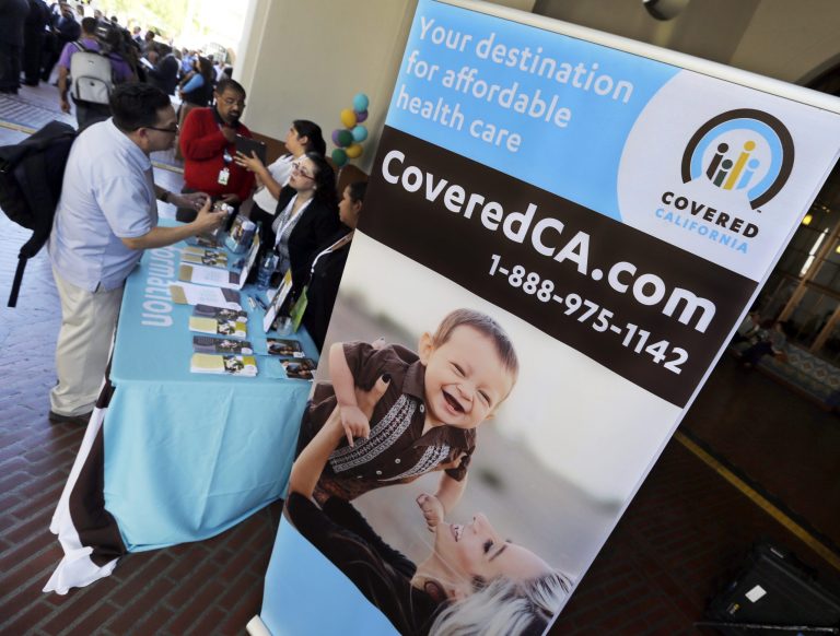 An information table is busy at Union Station in downtown Los Angeles as people seek information on state-provided health insurance, while a celebration is underway to inaugurate the first day people can enroll, Tuesday, Oct. 1, 2013. Californians who buy their own health insurance and those who have been hoping for coverage began using the state's online marketplace Tuesday after it opened for business on the first day of enrollment.   (AP Photo/Reed Saxon)