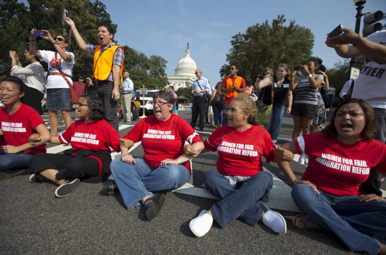   FILE - This Sept. 12, 2013, file photo shows women linking their arms and sitting in a circle to block the intersection outside the House of Representatives on Capitol Hill in Washington during a demonstration to protest Congress' inaction on comprehensive and inclusive immigration reform. Immigration overhaul legislation has been dormant in the House for months, but a handful of Republicans is working behind the scenes to advance it, even with the Capitol immersed in partisan brawling over spending and President Barack Obamaâs health law. (AP Photo/Carolyn Kaster, File)  