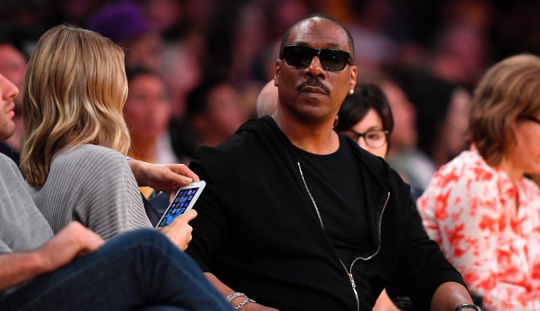 Actor Eddie Murphy, right, sits with actress Paige Butcher during the second half of an NBA basketball game between the Los Angeles Lakers and the Utah Jazz Sunday, April 8, 2018, in Los Angeles. The Jazz won 112-97.