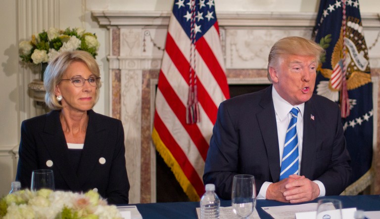 President Donald Trump, flanked by Education Secretary Betsy DeVos, left, and Labor Secretary Alexander Acosta, answers questions regarding the ongoing situation in North Korea, Friday, Aug. 11, 2017, at Trump National Golf Club in Bedminster, N.J.