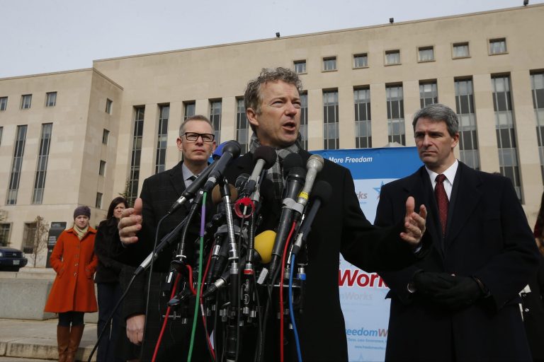Sen. Rand Paul, R-Ky., lead counsel Ken Cuccinelli, former Virginia Attorney General, and FreedomWorks director Matt Kibbe speak to reporters in front of federal court in Washington on Wednesday. (AP/Charles Dharapak)