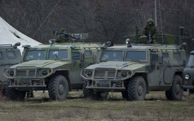 Russian soldiers sits atop an armored vehicle outside of Ukrainian military base in the village of Perevalne, outside of Simferopol, Ukraine, on Sunday, March 2, 2014. Hundreds of armed men in trucks and armored vehicles surrounded the Ukrainian military base Sunday in Crimea, blocking its soldiers from leaving. (AP Photo/Ivan Sekretarev)