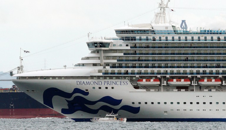 A small boat navigates near a cruise ship Diamond Princess anchoring off the Yokohama Port Tuesday, Feb. 4, 2020, in Yokohama, near Tokyo. Japanese health officials are conducting extensive medical checks on all 3,700 passengers and crew of the cruise ship that returned to the country after one passenger tested positive for the new coronavirus.