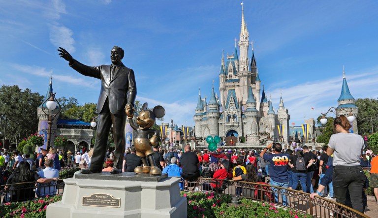 In this Jan. 9, 2019 photo, guests watch a show near a statue of Walt Disney and Micky Mouse in front of the Cinderella Castle at the Magic Kingdom at Walt Disney World in Lake Buena Vista, part of the Orlando area in Fla. 