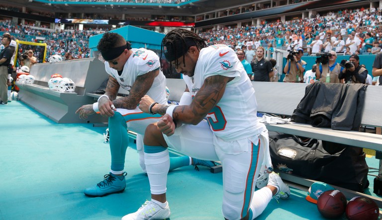 Miami Dolphins wide receiver Kenny Stills (10) and Miami Dolphins wide receiver Albert Wilson (15) kneel during the national anthem before an NFL football game against the Tennessee Titans, Sunday, Sept. 9, 2018, in Miami Gardens, Fla.
